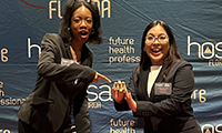  Student celebrating a big win by holding a gold medal at a medical professionals competition.
